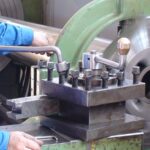 Final machining of 2-stroke piston rod on precision turning lathe to restore OEM geometry at KIMI.