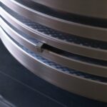 Certified KIMI technician performing NDT inspection on reconditioned piston crown grooves.