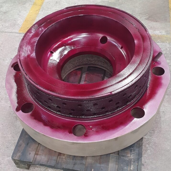 KIMI technician performing dimensional and NDT inspection on reconditioned 2-stroke cylinder cover.